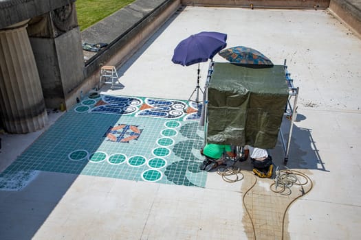 Darmstadt, Germany - June 28, 2021: workers are cleaning the art nouveau tiles at the floor of Mathildenhoehe in Darmstadt.