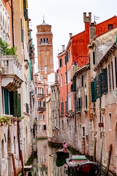 Venice, Italy - July 4, 2021: narrow canal in Venice with historic houses and a gondola  in Venice, Italy