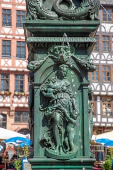 Frankfurt, Germany - July 18, 2021: detail of caritas figure at fountain Lady justice at the Roemer in Frankfurt am Main.