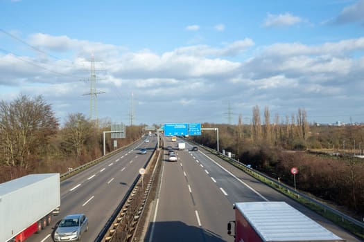 Frankfurt, Germany - January 28, 2022: view to german highway A5 with speed reduction to 120 km and blue signage for next exit.