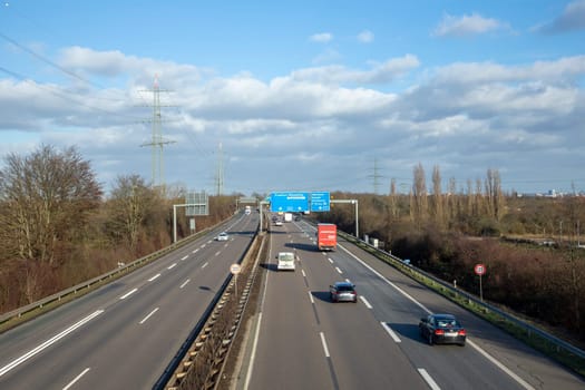 Frankfurt, Germany - January 28, 2022: view to german highway A5 with speed reduction to 120 km and blue signage for next exit.