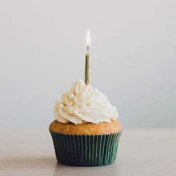 Delicious birthday cupcakes on table on light background