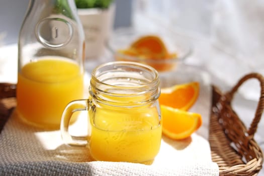 Orange juice poured into a mason jar mug cup