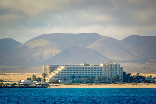 Corralejo, Spain, February 16th 2024: View on the sand dunes of Fuerteventura with Hotel Riu Palace Tres Islas