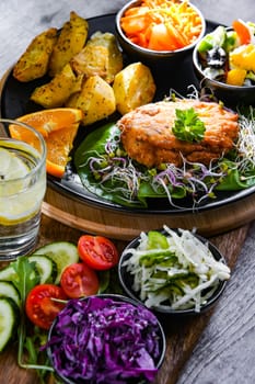 Pulled chicken cutlet coated with breadcrumbs with potatoes and vegetable salads