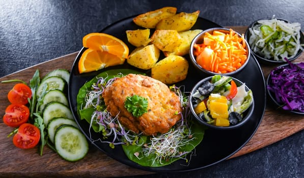 Pulled chicken cutlet coated with breadcrumbs with potatoes and vegetable salads