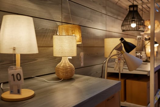 Modern lamp store market interior with assortment variety showcase. Different handmade and luxurious chandeliers, table or floor electric equipment for home design on shop stand