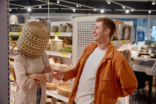 Depressed woman customer standing with wicker basket on head standing at household store department