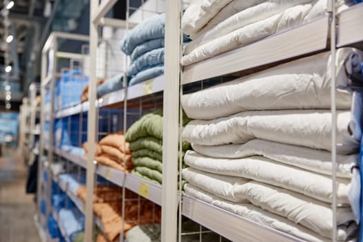 Shopping showcase rack with folded textile bedding items assortment with price sales tags. Modern linen shop store market offering linen with discount