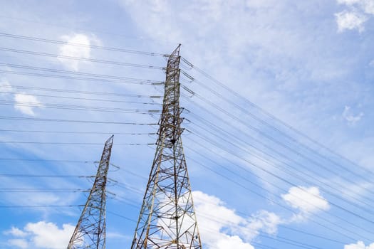 High voltage power line and pylon on blue sky