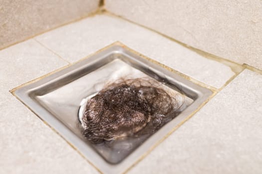 Clogged with dirty and hair over sewer pipes floor drain at bathroom