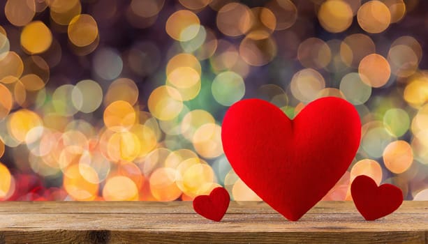 Valentines day composition with red heart against bright bokeh defocused background. Greeting festive card.