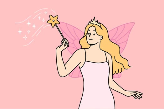 Fairy woman with magic wand performs sorcery, standing with wings behind back, dressed in dress and crown. Sorceress girl from fairy tale about cinderella flew in to help cope with difficulties