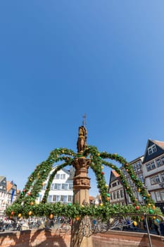 Butzbach, Germany - April 18, 2022:  market square with easter decoration at fountain in the old town of butzbach Germany.