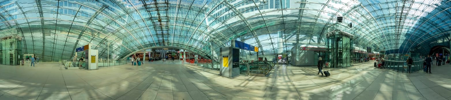Frankfurt, Germany - May 13, 2022: people in the modern business and train station building the square at the airport in Frankfurt, Germany.