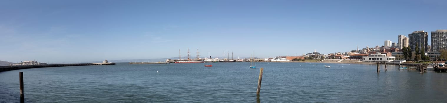 San Francisco, USA - May 18, 2022: panoramic view to fishermans wharf area in San Francisco with skyline and old traditional boats at Hyde street pier.