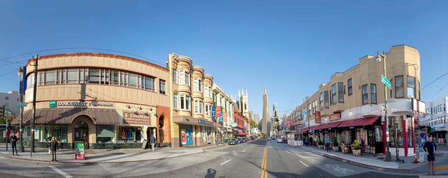 San Francisco, USA - May 18, 2022:  old houses in downtown San Francisco in bright light with view to transamerica pyramid.