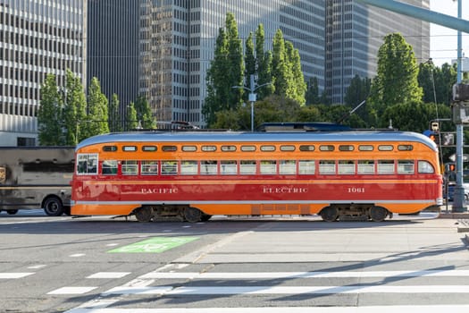 San Francisco, USA - June 6, 2022:  yellow vintage bus operates from Fisherman's wharf to market street downtown San Francisco. Tourists enjoy traveling with this electric vintage bus.