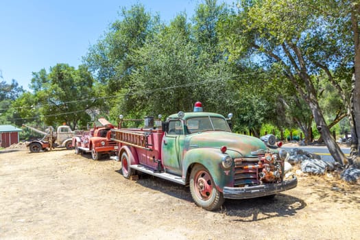 Three Rivers, USA - May 21, 2022: old vintage dirty  fire engine car at an outdoor loam parking lot in three rivers.