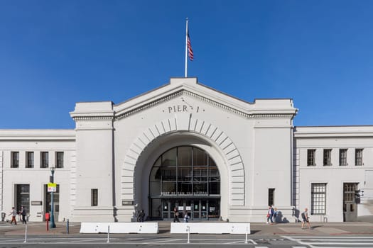 San Francisco, USA - May 20, 2022: facade of historic Pier 1 building with people at the harbor promenade in San Francisco, USA.
