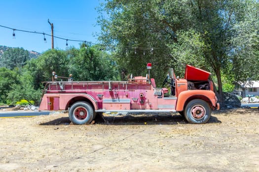 Three Rivers, USA - May 21, 2022: old vintage dirty  fire engine vintage car at an outdoor loam parking lot in three rivers.