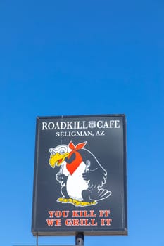 Seligman, USA - May 25, 2022: advertising for Roadkill cafe with slogan you kill it we grill it at an enamle plate at route 66 in Seligman.