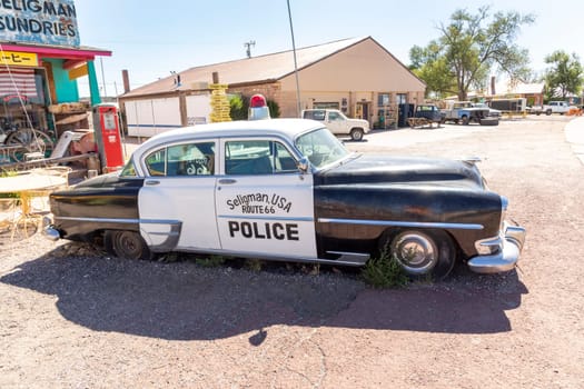 Seligman, USA - May 25, 2022: vintage historic police car at a shop and a route 66 souvenir shop in Seligman, USA.