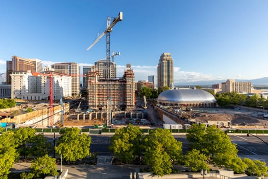 Salt Lake City, USA - May 28, 2022: view to Salt Lake Tabernacle (Church of Jesus Christ of Latter-day Saints) and the old temple under construction with downtown skyline of Salt Lake city.