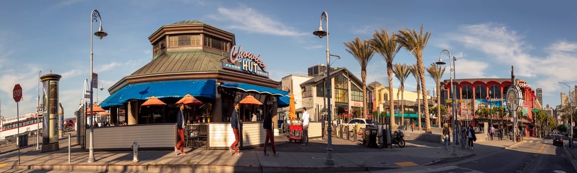 San Francisco, USA - June 7, 2022:  people enjoy eating and looking at fishermans wharf in San Francisco on a sunny afternoon.