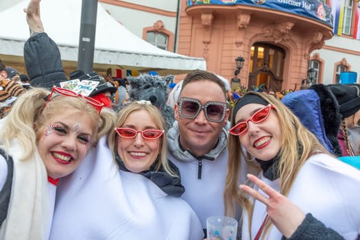 Mainz, Germany - February 16, 2023: people celebrate the Weiberfastnacht - engl womans carnival - in Mainz at the schiller square in Germany.