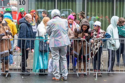 Osnabrueck, Germany - February 19, 2023: people celebrate the carnival parade in Osnabrueck on a rainy day.