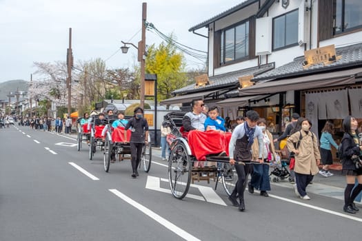 Kyoto, Japan - March 25, 2023:  japanese tourists like to go on a sightseeing trip by rickshaw in Kyoto.
