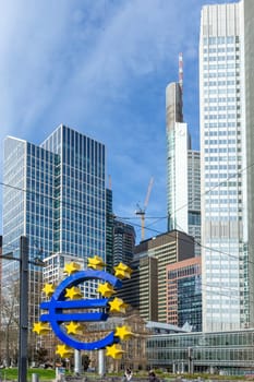 Frankfurt, Germany - March 28, 2023: the Euro sign in Frankfurt in front of skyscraper and the former european central bank building.