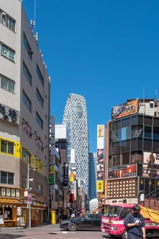 Tokyo, Japan - March 19, 2023: Street view of Nishi Shinjuku Shopping street whith several Japanese Restaurants on the sides. Mode Gakuen Cocoon Tower is at the background.