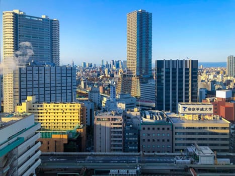 Tokyo, Japan - March 17, 2023: skyscraper in downtown tokyo uner blue sky.