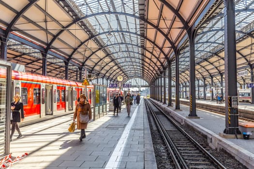 Wiesbaden, Germany - April 4, 2023:  people wait in the train station for departure in classicistic train station in Wiesbaden, the smaller copy of Frankfurt Train station.