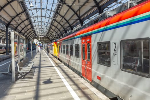 Wiesbaden, Germany - April 4, 2023:  people wait in the train station for departure in classicistic train station in Wiesbaden, the smaller copy of Frankfurt Train station.