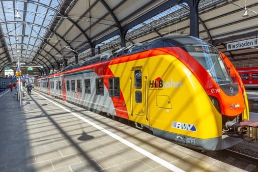 Wiesbaden, Germany - April 4, 2023:  people wait in the train station for departure in classicistic train station in Wiesbaden, the smaller copy of Frankfurt Train station.