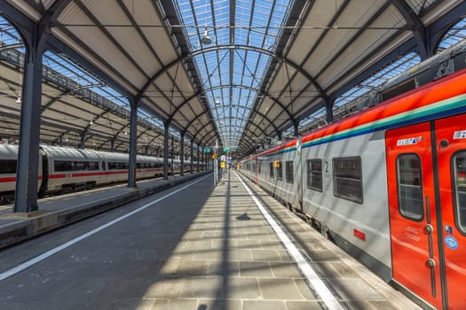 Wiesbaden, Germany - April 4, 2023:  people wait in the train station for departure in classicistic train station in Wiesbaden, the smaller copy of Frankfurt Train station.