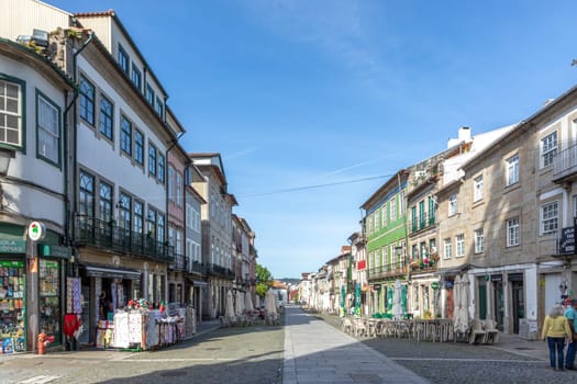 Braga, Portugal - May 1, 2023:street scene in the old town of Braga with historic facades and people in early morning.