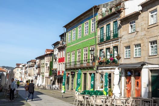 Braga, Portugal - May 1, 2023:street scene in the old town of Braga with historic facades and people in early morning.