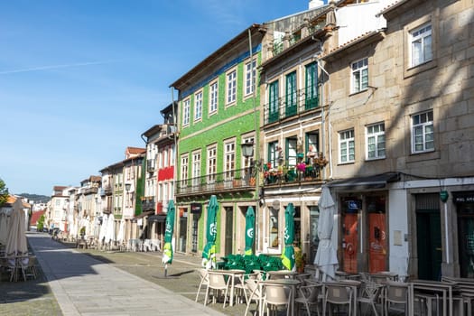 Braga, Portugal - May 1, 2023:street scene in the old town of Braga with historic facades and people in early morning.