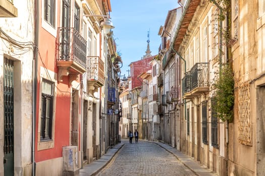 Braga, Portugal - May 1, 2023: street scene in the old town of Braga with historic facades and people in early morning.