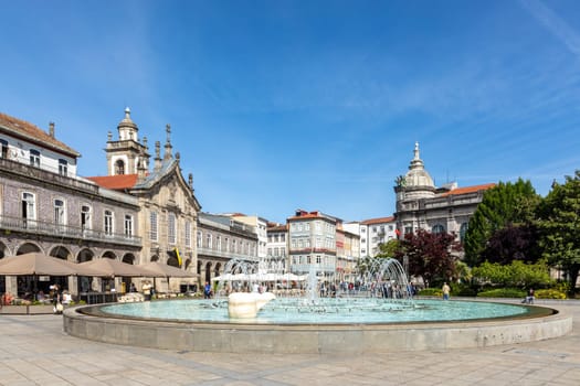 Braga, Portugal - May 1, 2023: sunrise view of Praca da Republica in the historical center of Braga, Portugal with reflection in fountain.