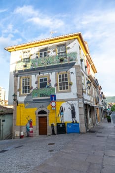 Chaves, Portugal - May 1, 2023: scenic narrow street in Chaves in early morning light with cobble stones and old historic houses.