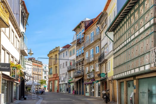 Braga, Portugal - May 1, 2023: street scene in the old town of Braga with historic facades and people in early morning.