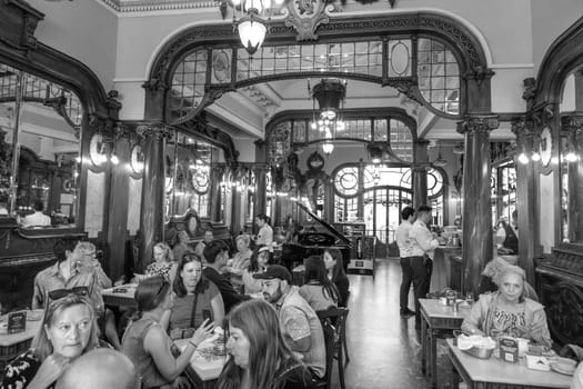 Porto, Portugal - May 4, 2023: people enjoy the style, cake and Interior of the Majestic cafe in Porto.