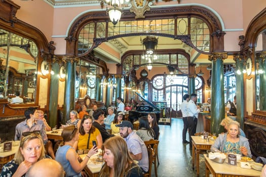 Porto, Portugal - May 4, 2023: people enjoy the style, cake and Interior of the Majestic cafe in Porto.