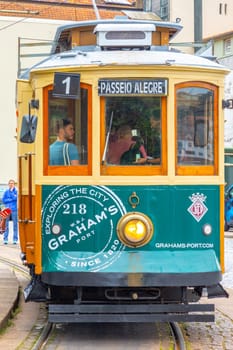 Porto, Portugal - May 4, 2023: Porto, vintage Portuguese traditional city tram Infante 1 designed with advertisements with the view on the river