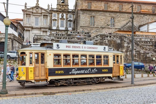 Porto, Portugal - May 4, 2023: Porto, vintage Portuguese traditional city tram Infante 1 designed with advertisements with the view on the river